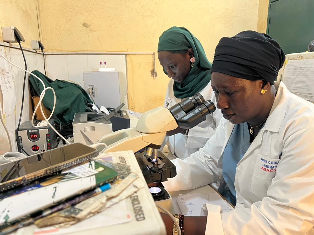 Technicienne du laboratoire du CSCom-U de Banconi au microscope