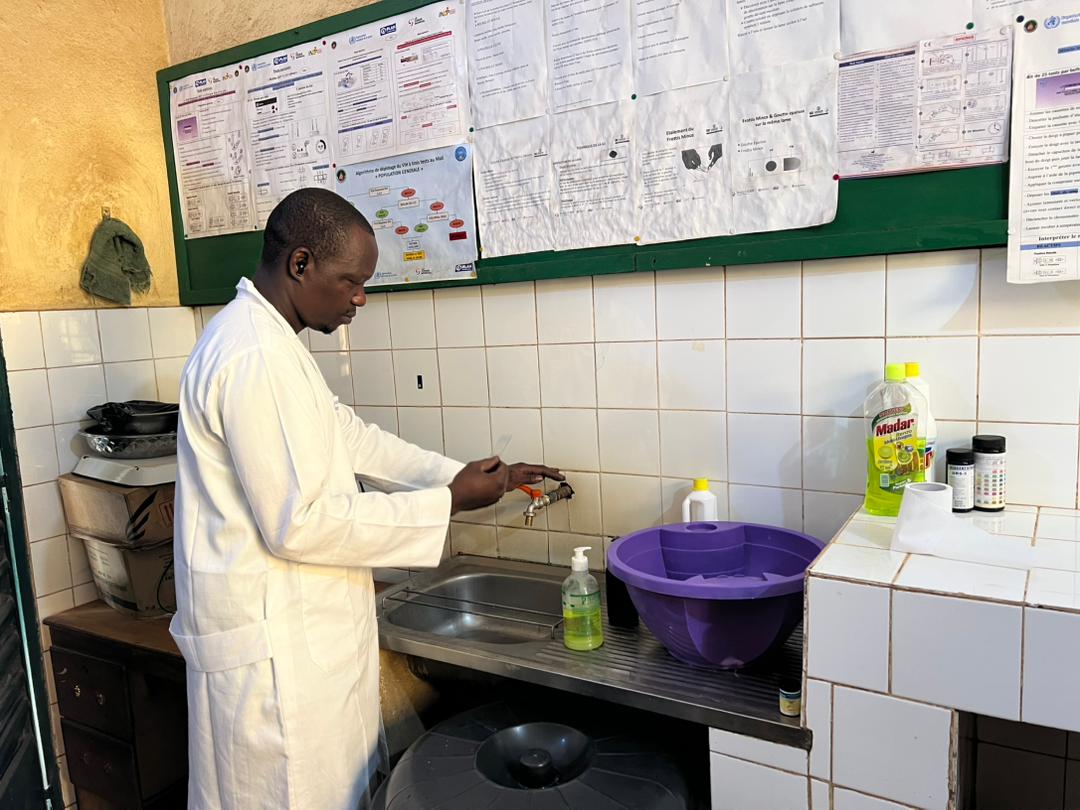 Technicien de laboratoire respectant les règles d'hygiène près du lavabo